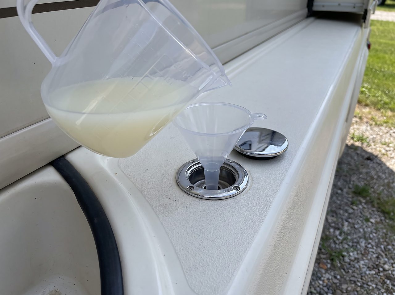 measuring diluted bleach solution before adding it to an RV fresh water tank