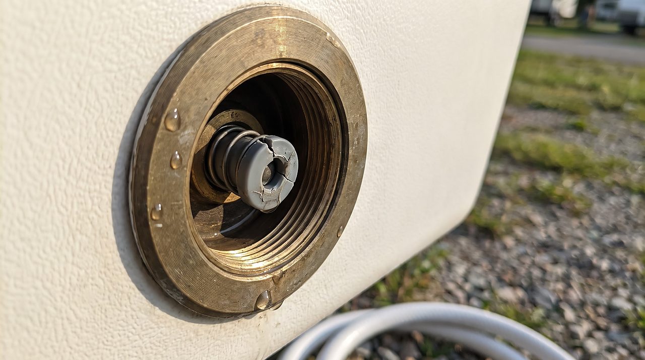 close-up of a worn spring-loaded plunger inside an RV city water connection inlet