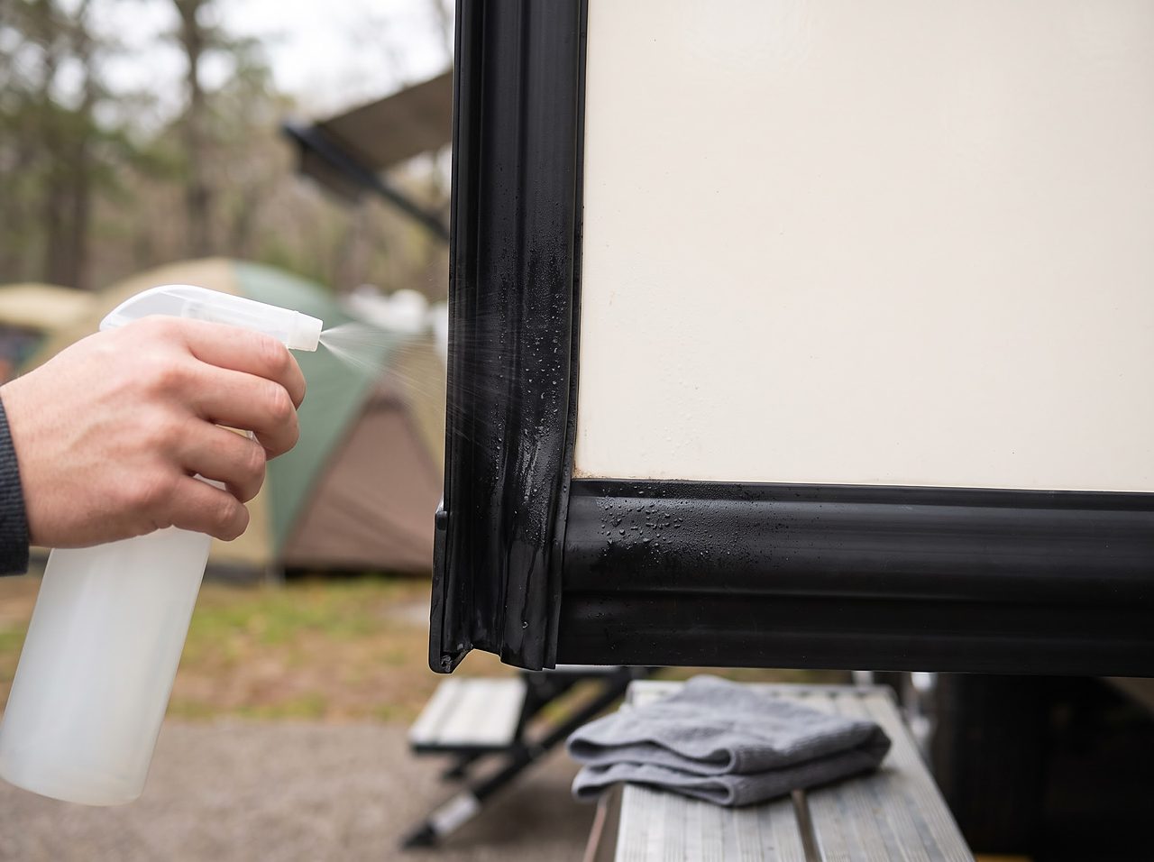 hand applying rubber seal conditioner to a slide-out wiper seal along the wall seam