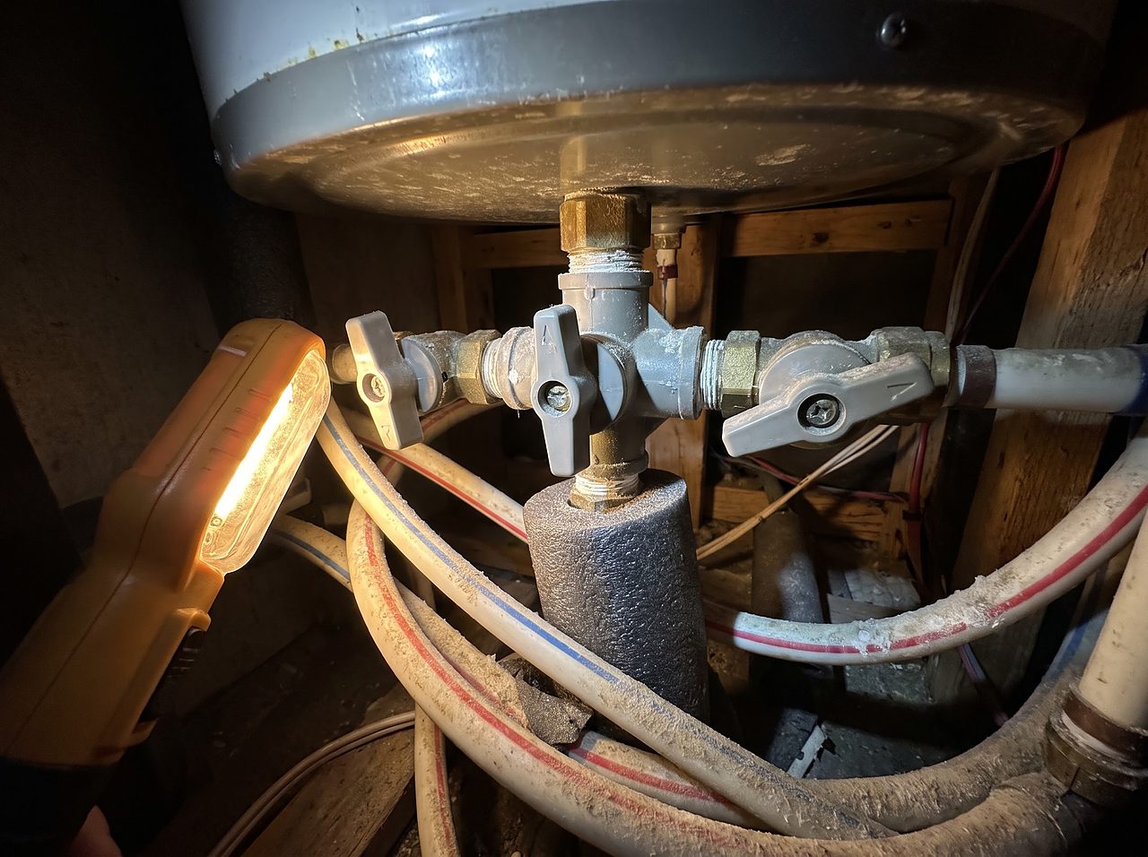 three-way bypass valve and water lines behind an RV water heater tank
