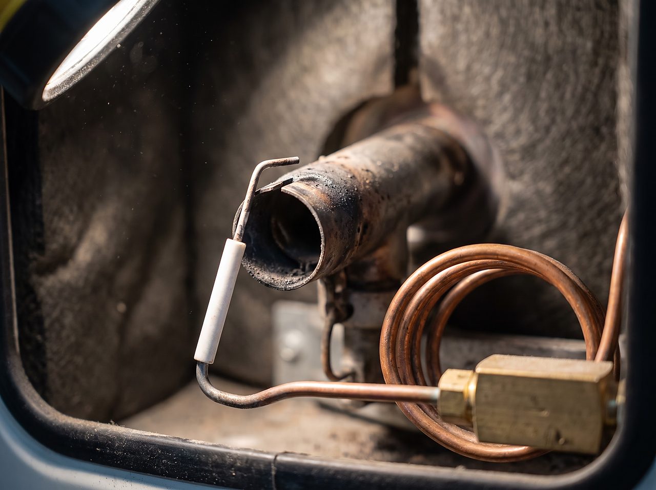 close-up of an RV water heater direct spark ignition electrode and burner assembly