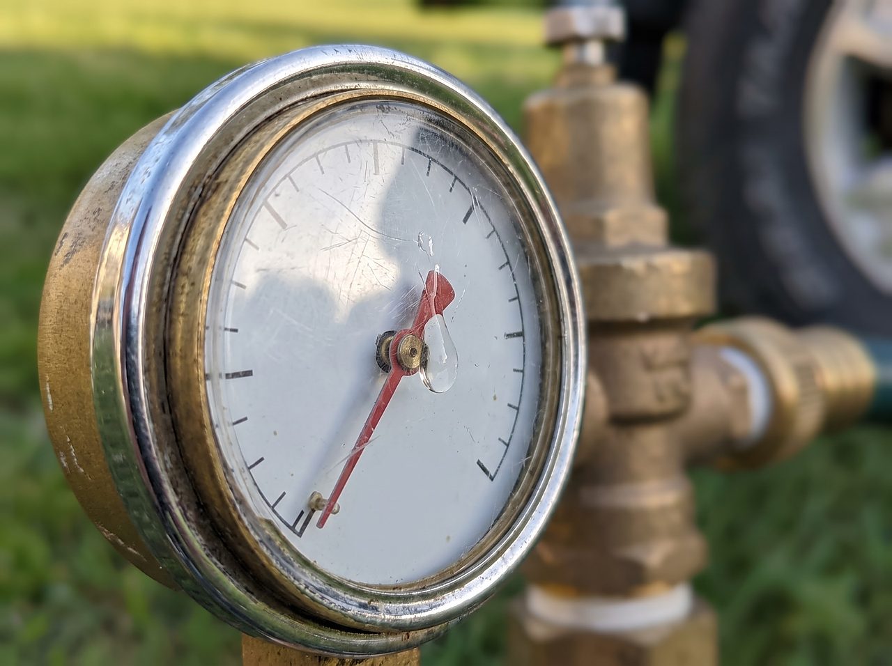 close-up analog gauge on an adjustable water pressure regulator showing a safe reading